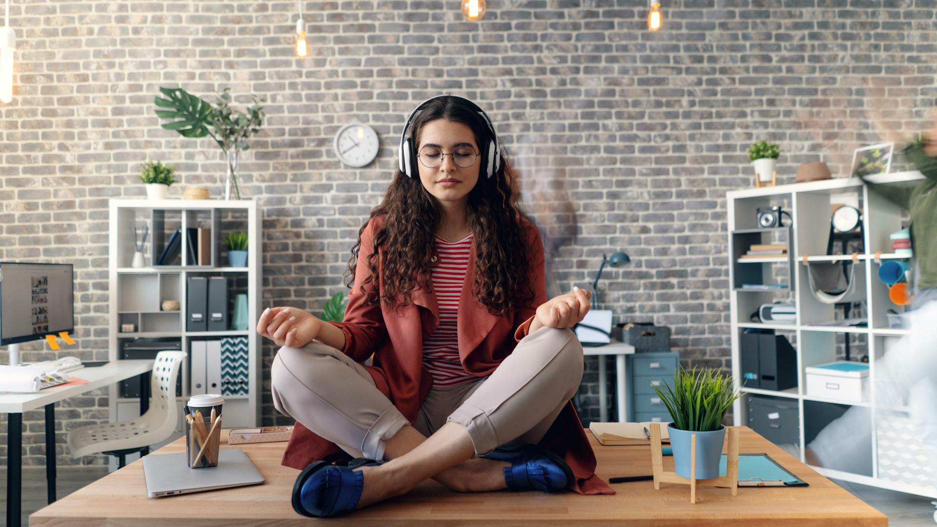 alt=Woman doing seated cat-cow stretch at office desk)